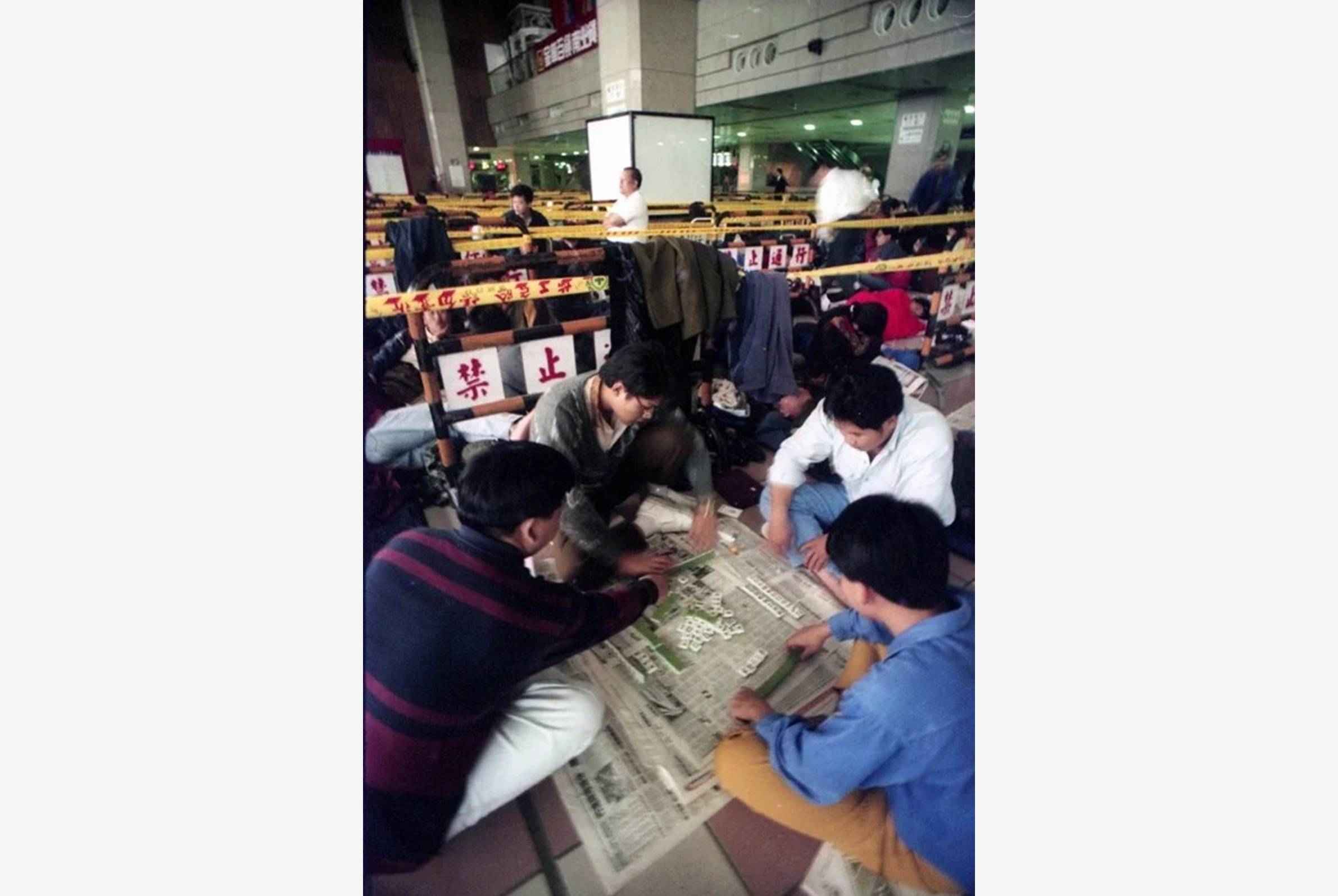 圖／聯合報系資料照片，洪克紀攝影，1994年。 1994年，台北車站開始預售車票，趕搭春節返鄉班車的民眾，在車站打地舖等買票。