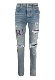 AMIRI ripped-knee logo-print skinny jeans - Blau