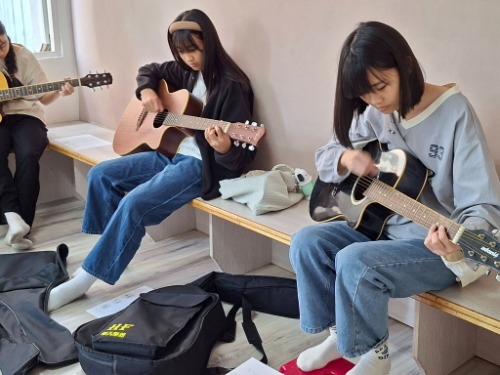 可能是一或多人、吉他和文字的圖像