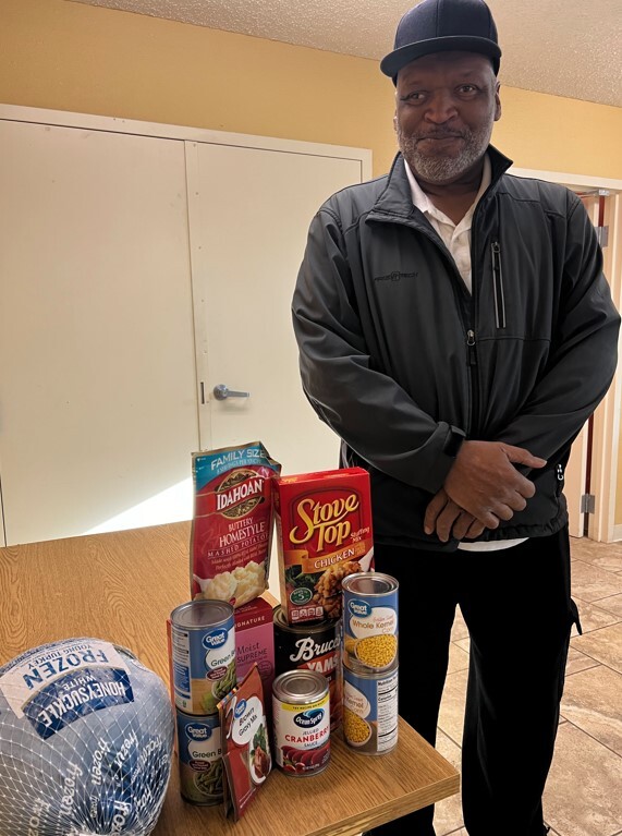 A man standing next to a table with the contents of a Christmas box.