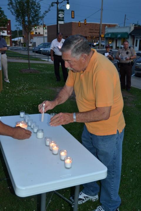 Retired Marion County  Lt. Harold Pendley lighting a candle.