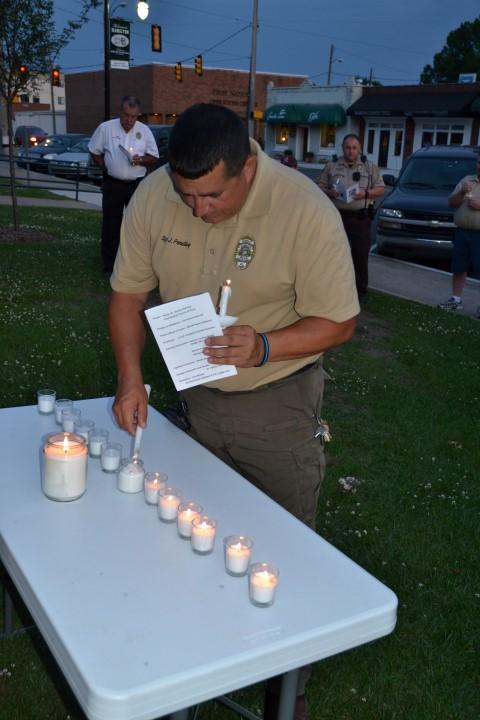 Hamilton PD Sgt. Jimmy Pendley lighting a candle.