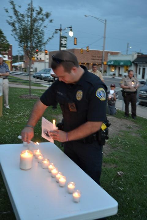 Hamilton PD Officer Zach Langston lighting a candle.