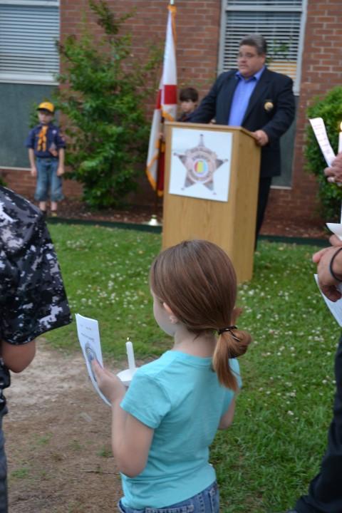 FOP President Daniel Gonzalez speaking at a podium with a child in front.