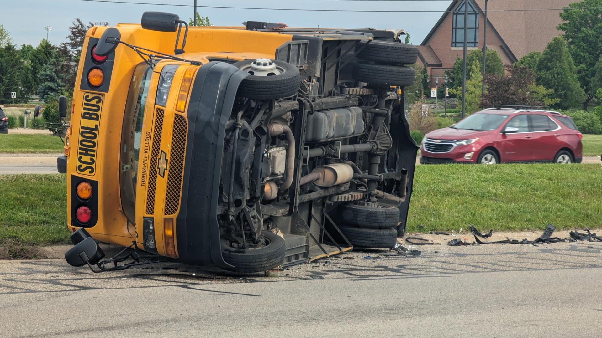 Staffer, other driver injured after crash causes school bus to roll