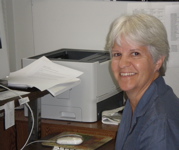 Ceil Lucas at her desk, smiling at the camera.