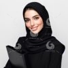 a beautiful young Arab female secretary dressed formally in black and wearing a hijab with a friendly expression and smile carrying a file-538890254