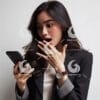 beautiful young Indonesian woman in formal clothes, looking at a cellphone screen with a shocked expression-093238