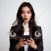 beautiful young Indonesian woman in formal clothes, looking at a cellphone screen with a surprised expression-085769977