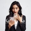 beautiful young Indonesian woman in formal clothes, looking at a cellphone screen with a surprised expression-75444381