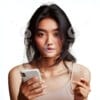 beautiful young Indonesian woman looking at a cellphone screen-5609334998