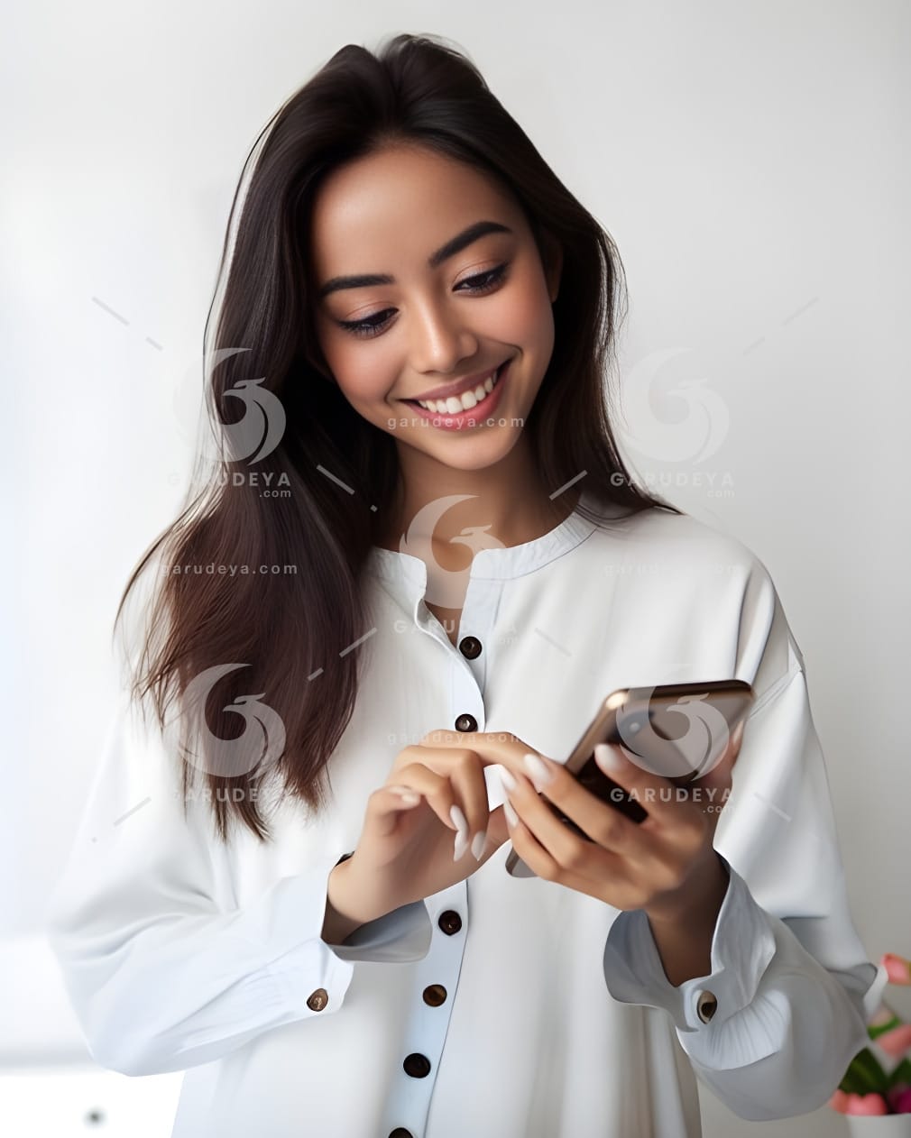 beautiful young Indonesian woman looking at a cellphone screen with a cheerful expression-32809881