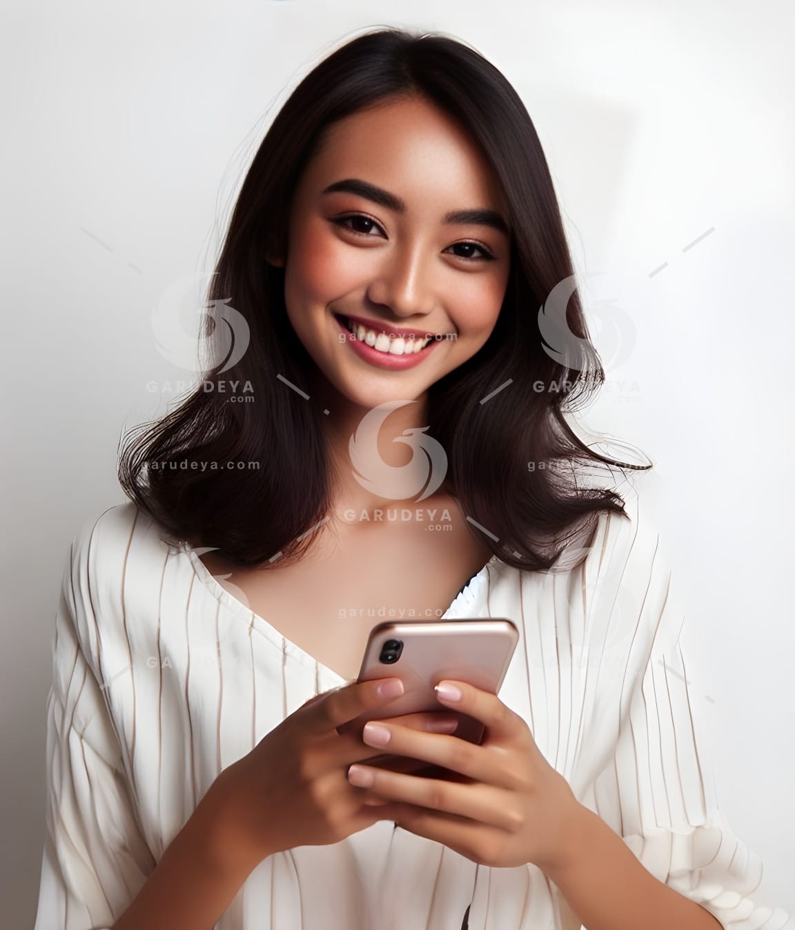 beautiful young Indonesian woman looking at a cellphone screen with a cheerful expression-330905848