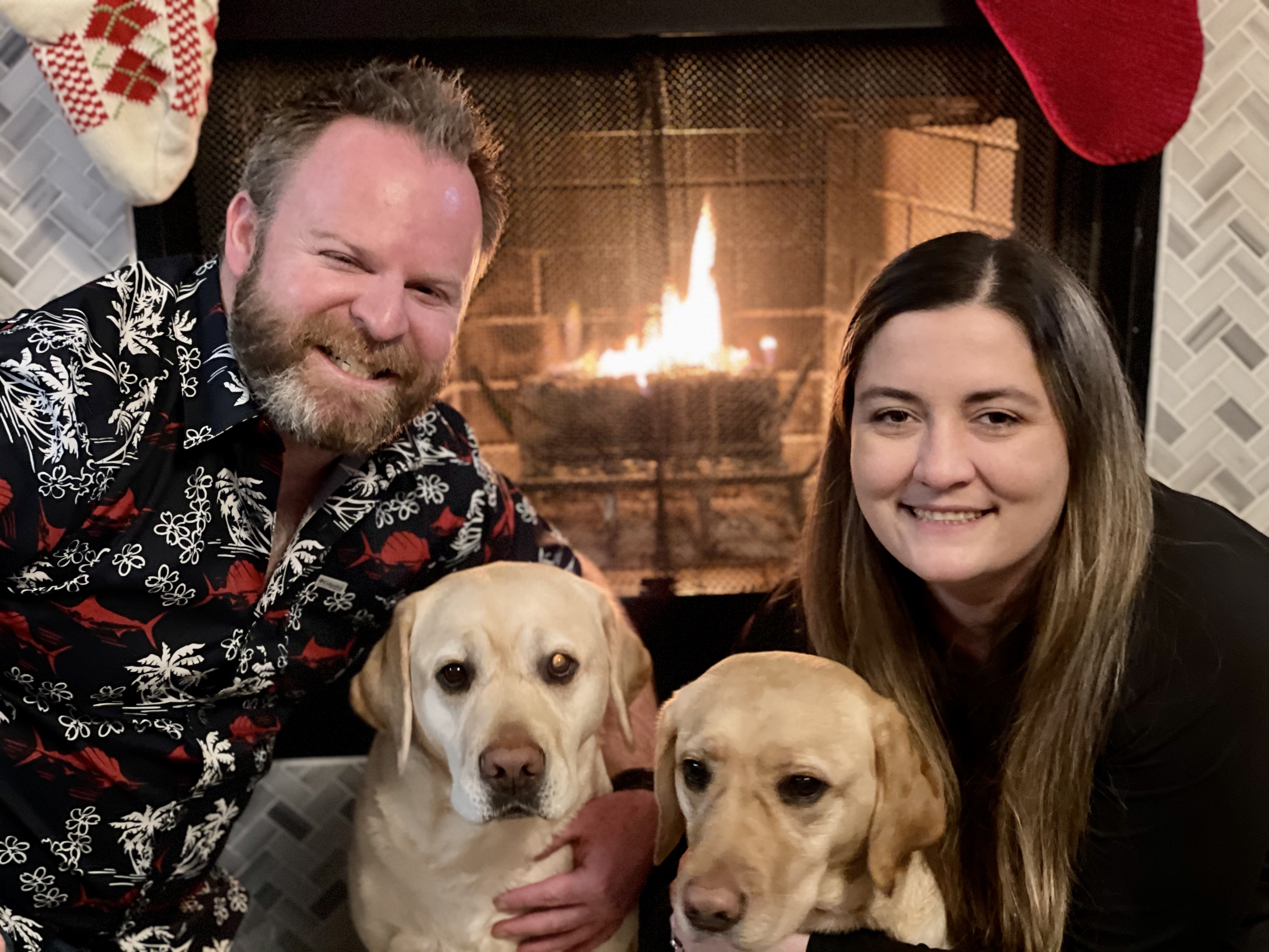 couple with dogs in front of fireplace