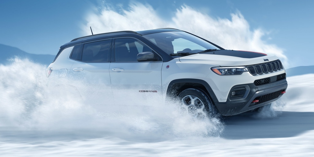 White Jeep Compass Trailhawk driving through snow 