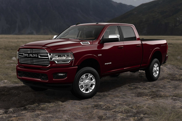 Red 2022 Ram 2500 in a field with a mountain backdrop low light setting 