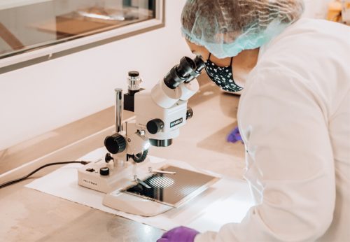 woman looking through microscope