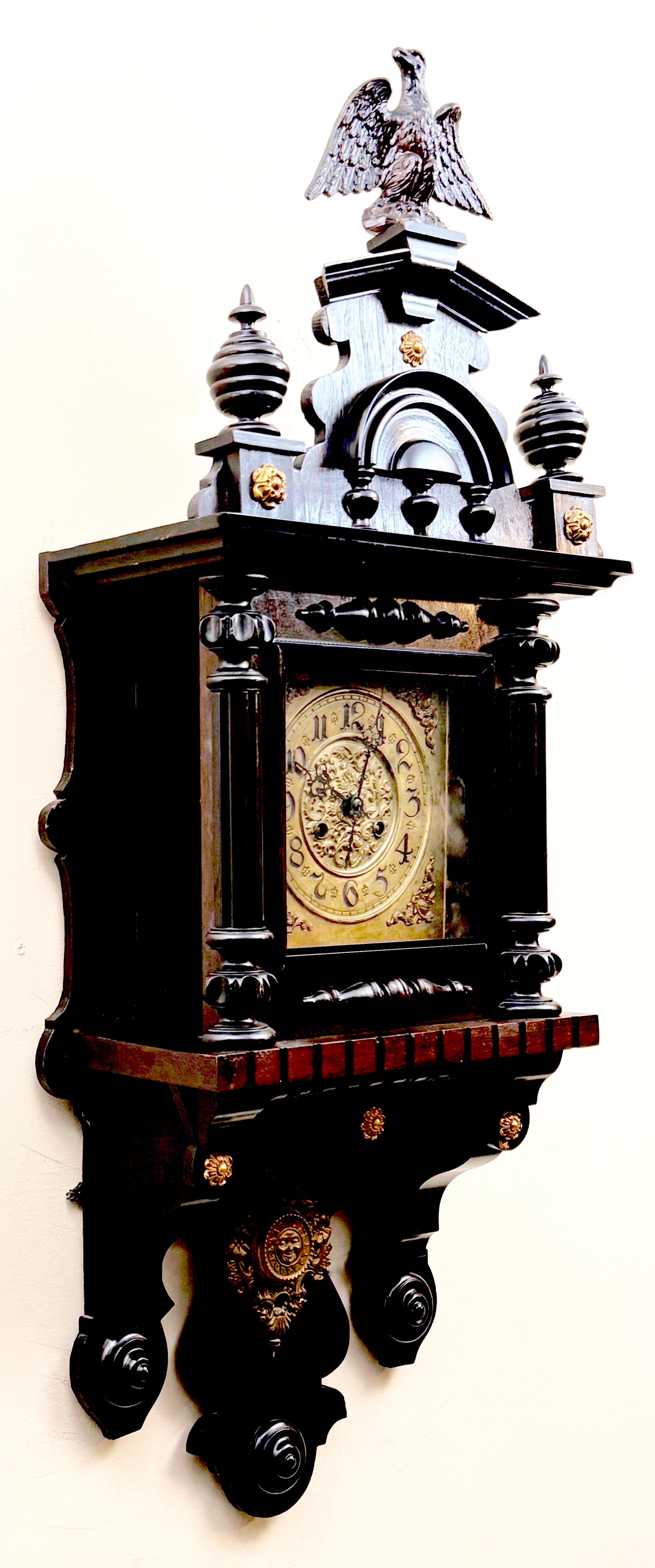 Dekoracyjny zegar ścienny zdobiony na szczycie orłem