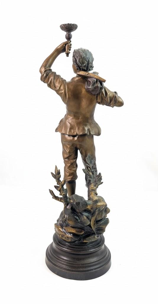 Dekoracyjna figura młodego wędrowca stojąca na cokole