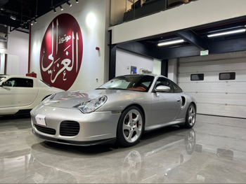 بورش  911  توربو  2003  اوتوماتيك  103,000 كم  6 سلندر  دفع خلفي  كوبيه \ سبورت  فضي