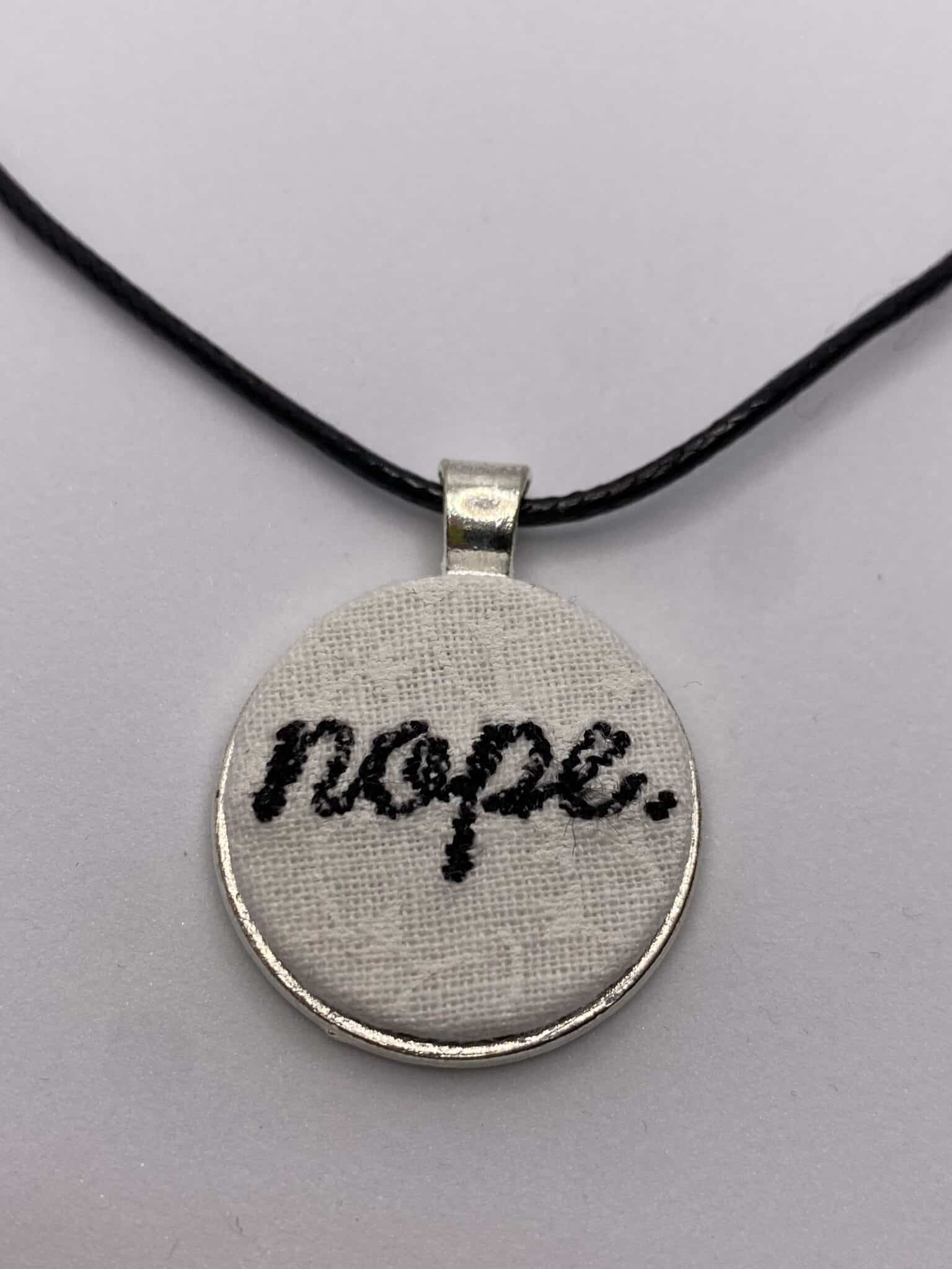 Embroidered Nope pendant on 16 inch black cord necklace - main product image