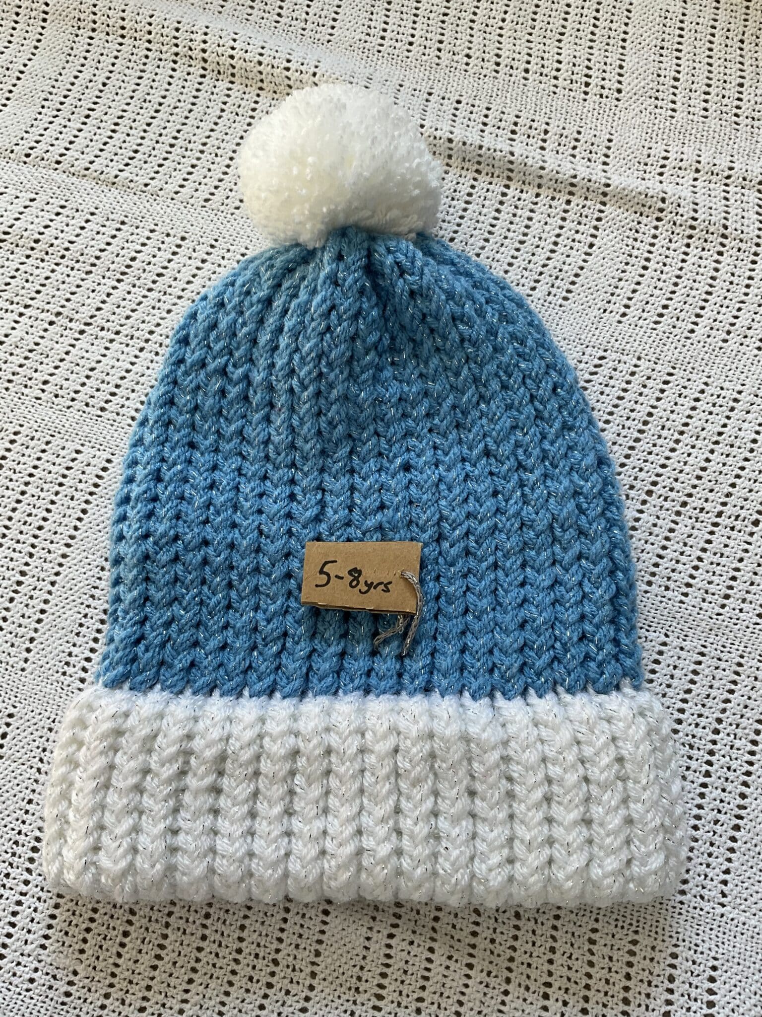 Handknitted 5-8yrs Blue and white glitter Pom Pom hat - main product image
