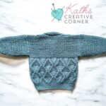 Hand knitted baby cardigan in petrol