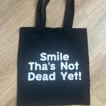 Black Tote with Smile Thas Not Dead Yet slogan, shopper,