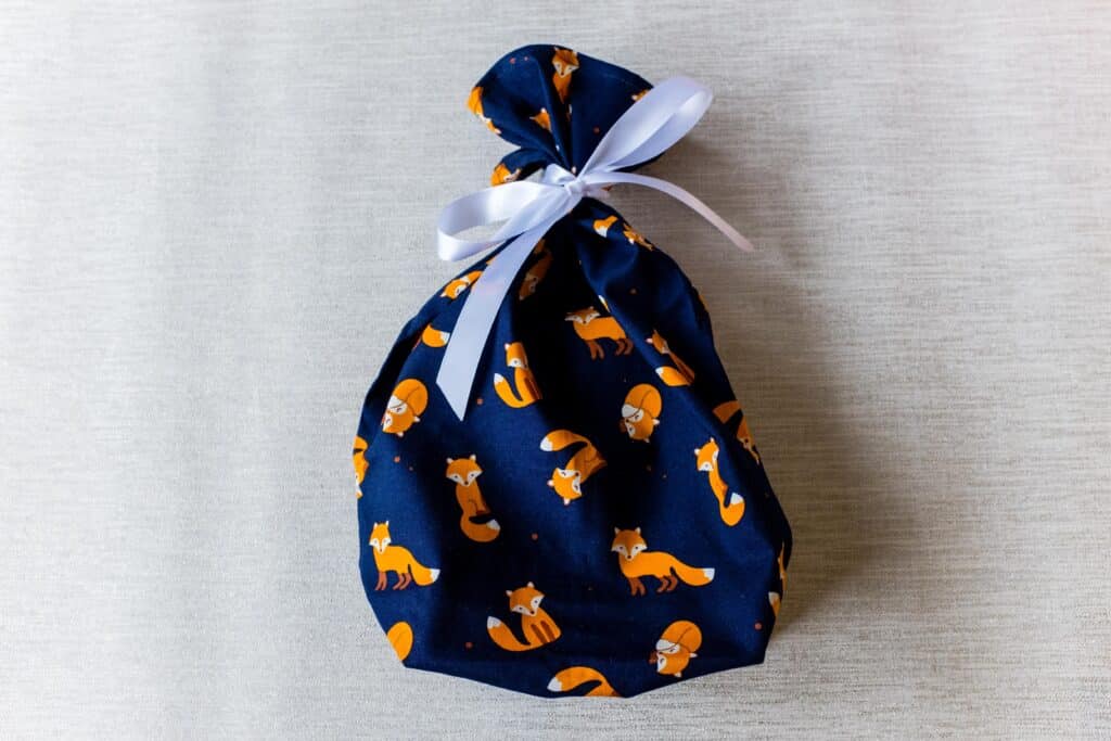 Small fabric gift bag, cute foxes on a navy blue background