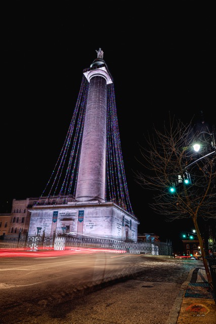 A car drives by the Washington Monument at night