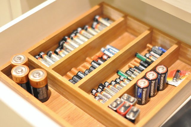 Silverware tray in a drawer holding batteries organized by size.