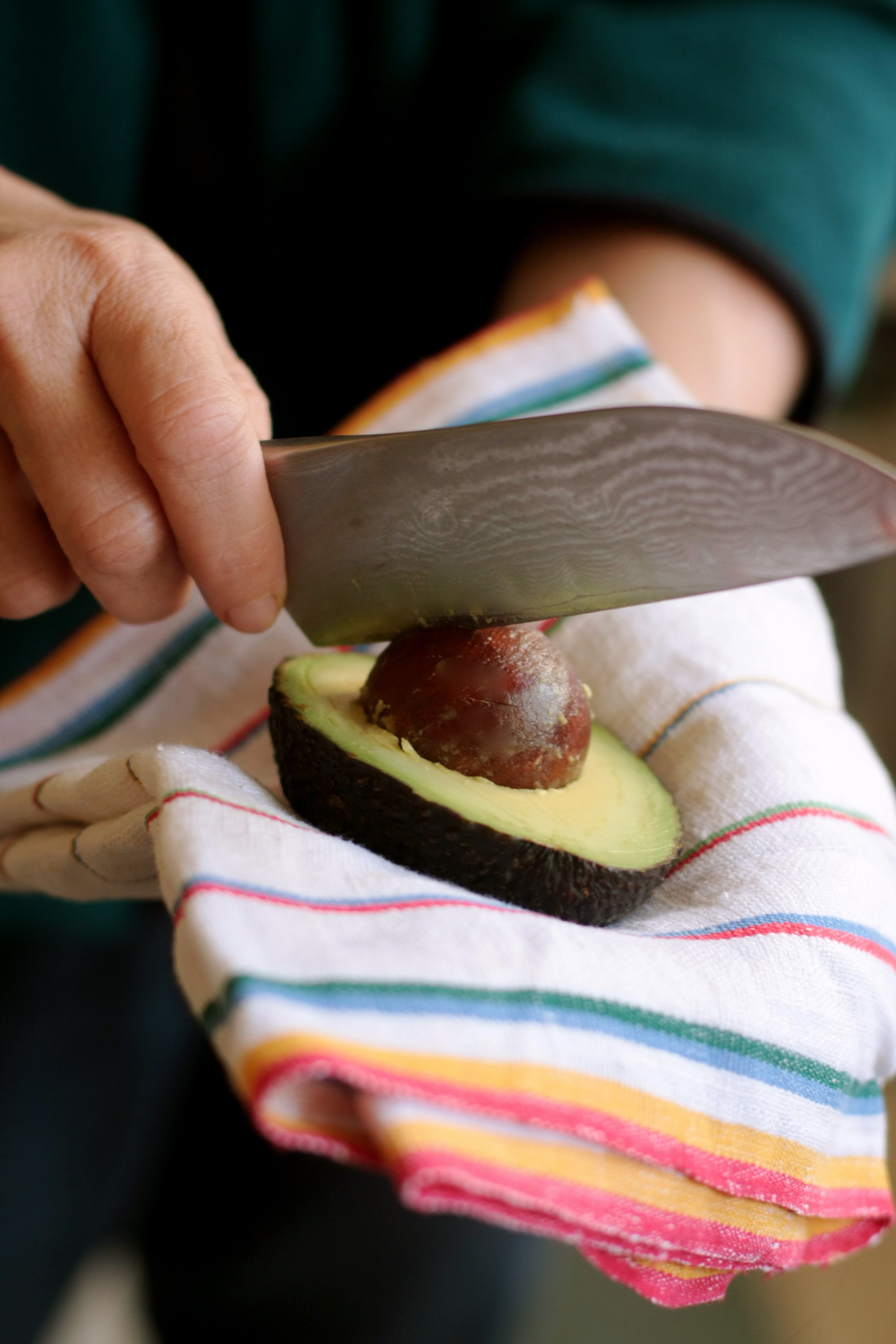 Man Removing a Pit from an Avocado Stock Photo - PixelTote