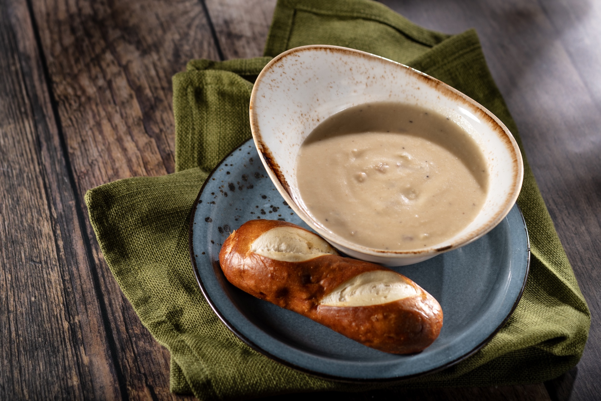 Cheddar and Bacon Soup, served with a pretzel roll (Introduced in 2000), served at Canada during the 2026 EPCOT International Food and Wine Festival