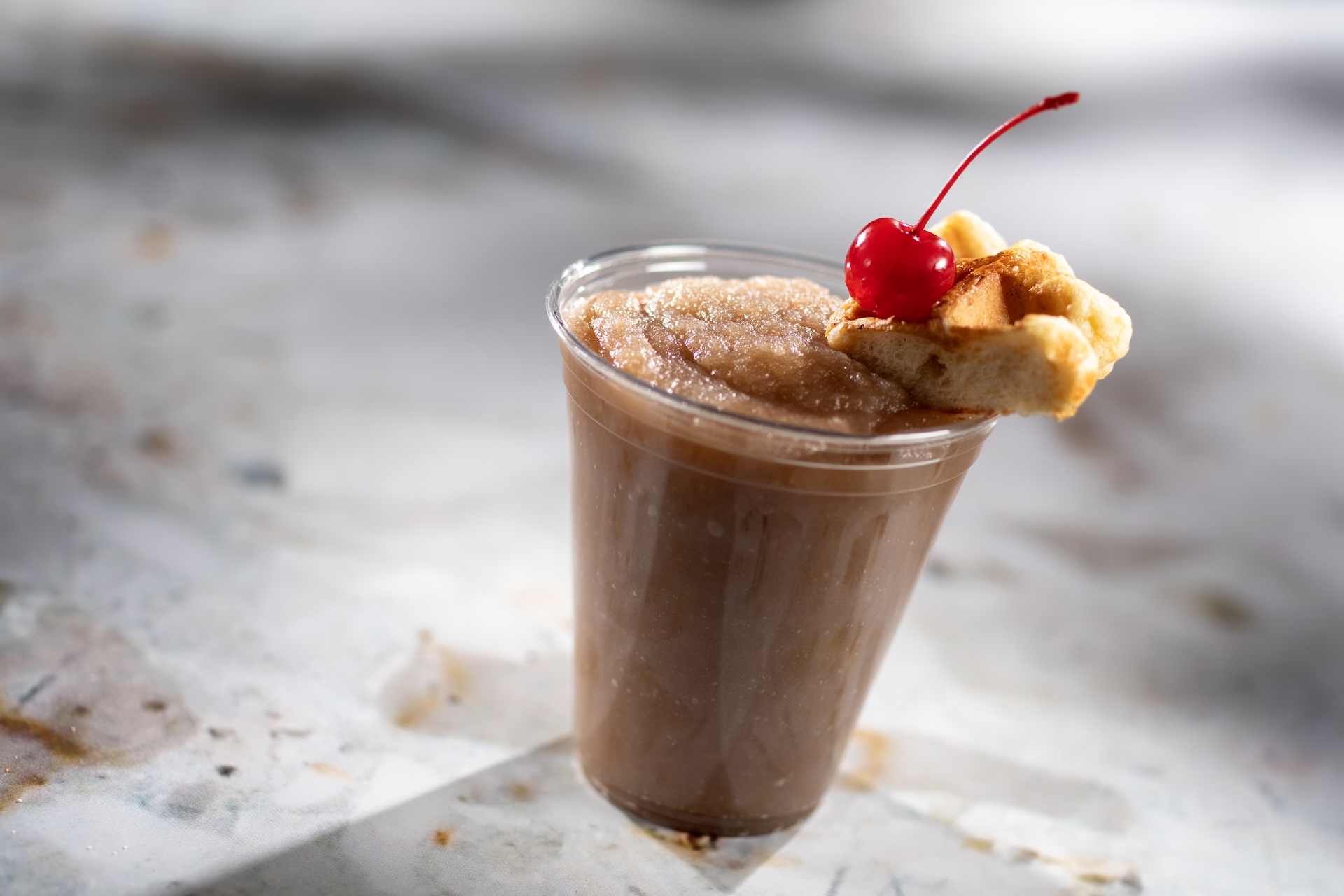 Frozen Waffle Old Fashioned, A frozen blend of Maker's Mark Kentucky Straight Bourbon Whisky, maple syrup, butterscotch syrup, and angostura bitters topped with a liege waffle and cherry, served at Connections Eatery Festival during the 2026 EPCOT International Food and Wine Festival