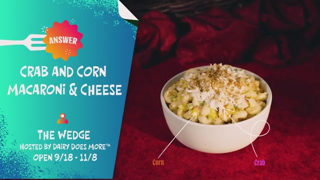 A bowl of crab and corn macaroni and cheese is presented on a red surface, with text providing details about the dish and an event.