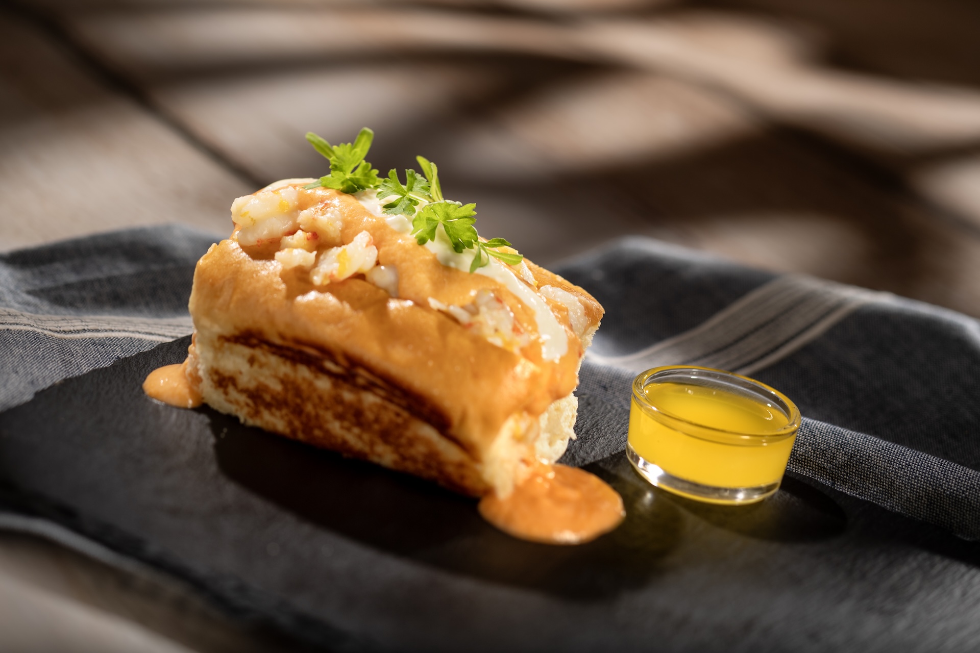 Gulf Coast-style Seafood Roll, with warm-water lobster, rock shrimp, lobster bisque, and sherry crème fraîche on a toasted brioche bun (Introduced in 2006), served at Hops & Barley during the 2026 EPCOT International Food and Wine Festival