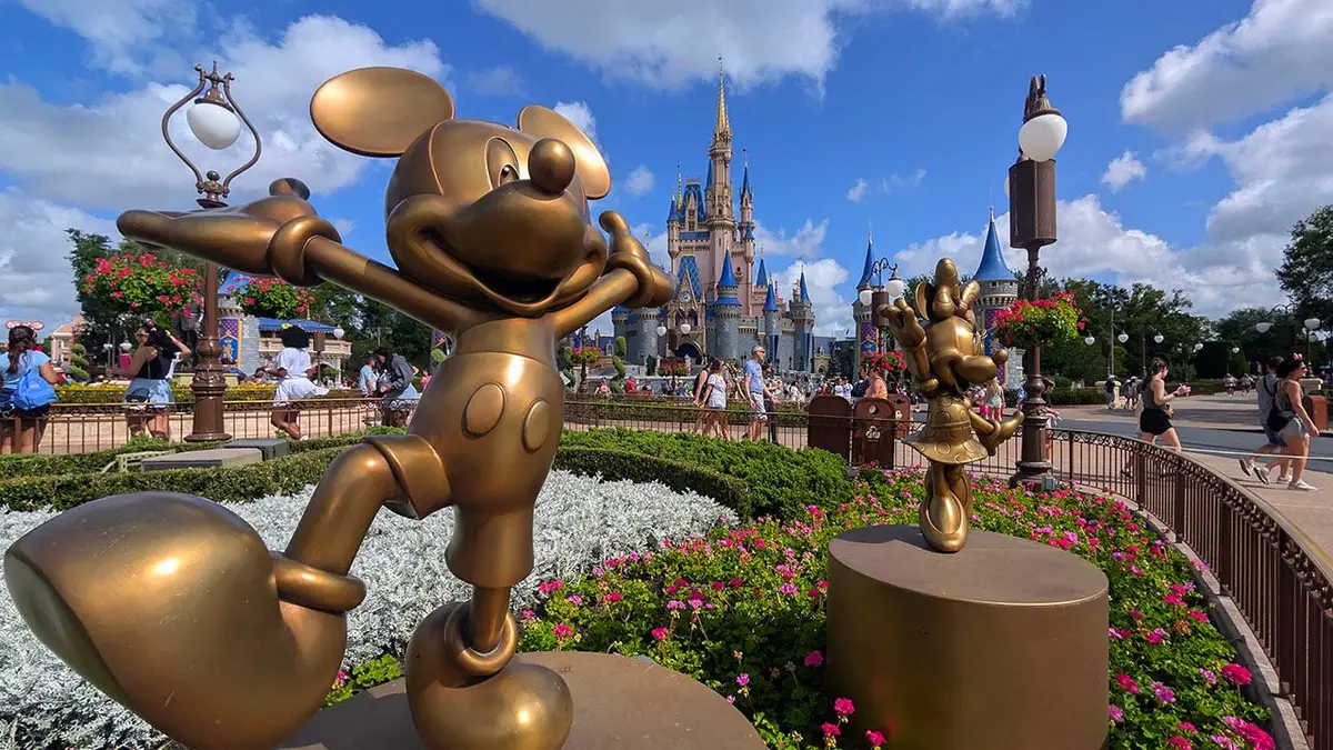 Mickey Mouse and Minnie Mouse statues in a garden in front of Cinderella Castle at Magic Kingdom