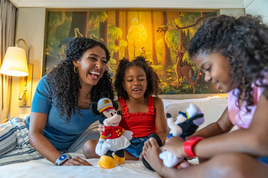 Family with Mickey Mouse and Minnie Mouse stuffed animals in a stateroom on a Disney Cruise