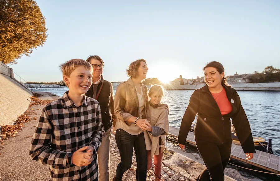 Family walking along a river with an Adventures by Disney Adventure Guide