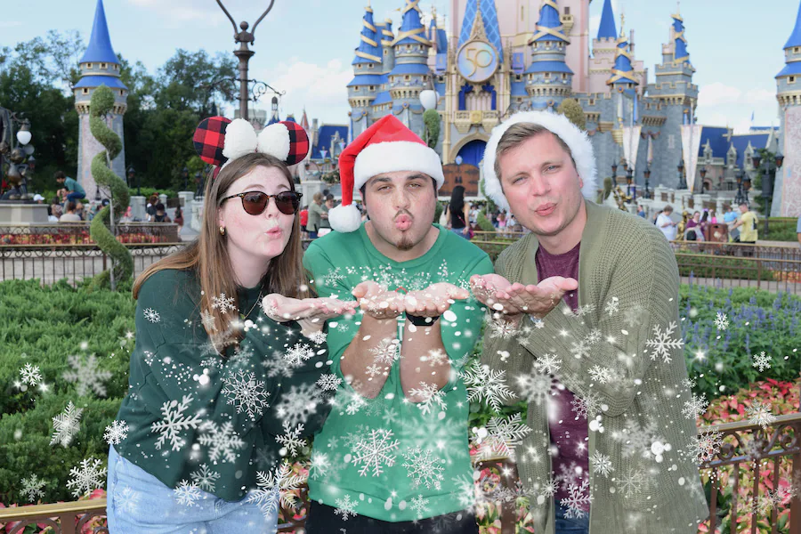 Guests posing with a festive holiday Disney PhotoPass prop at Walt Disney World
