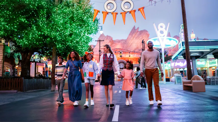 A family walking through Cars Land with a Disney Private VIP Tour Guide at Oogie Boogie Bash