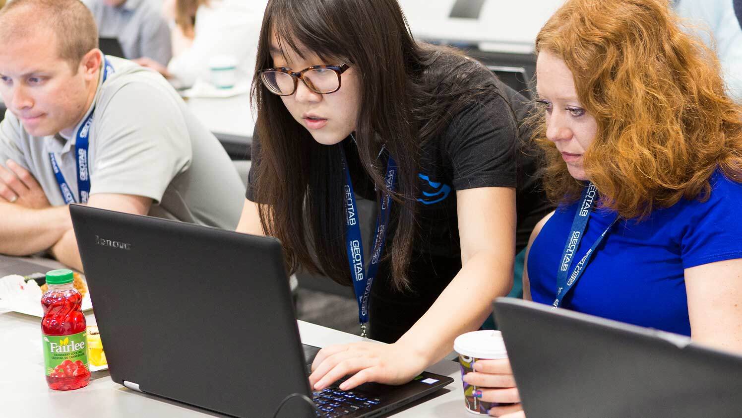A woman leans over a laptop