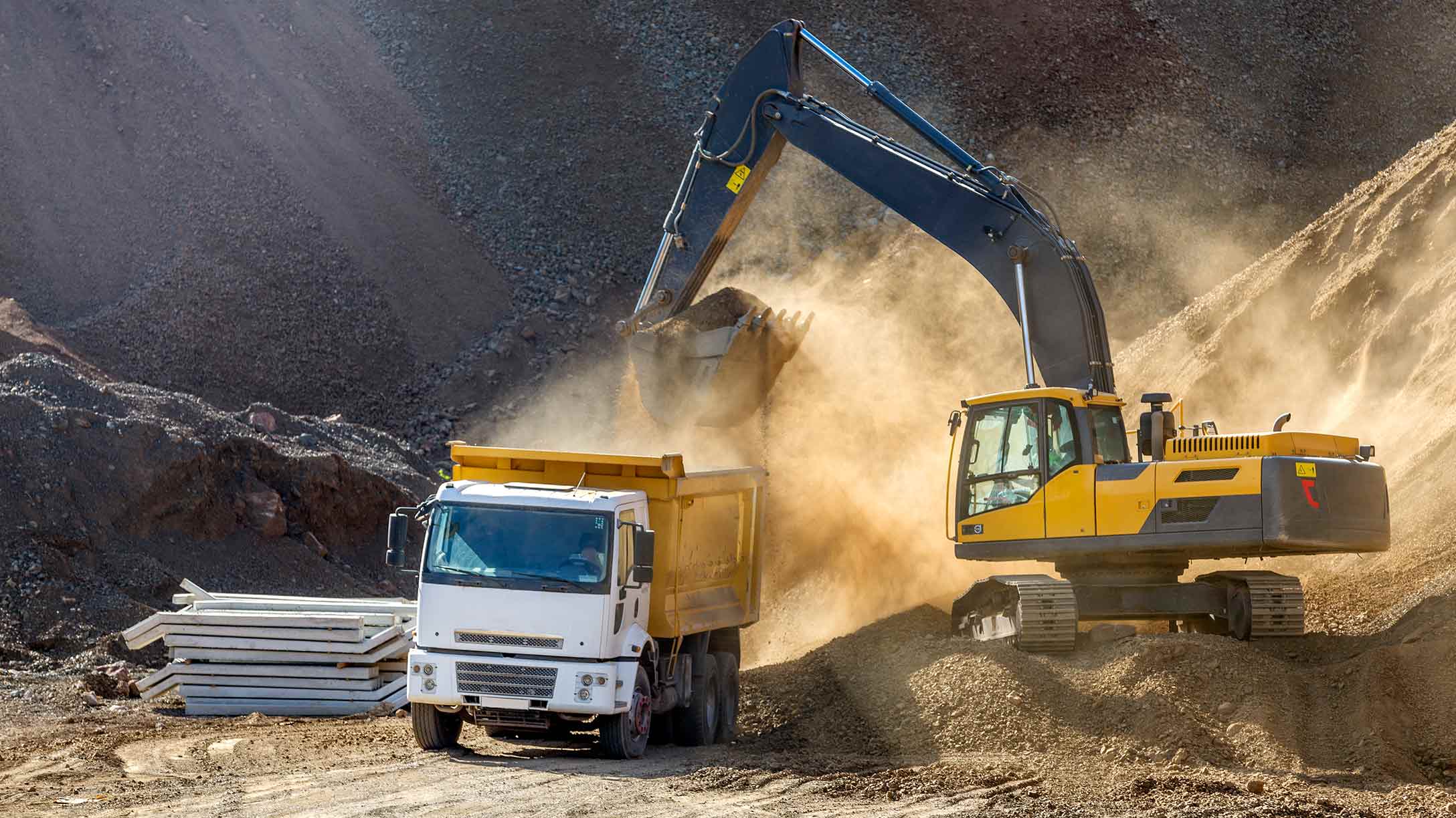 A construction truck and excavator at a construction site