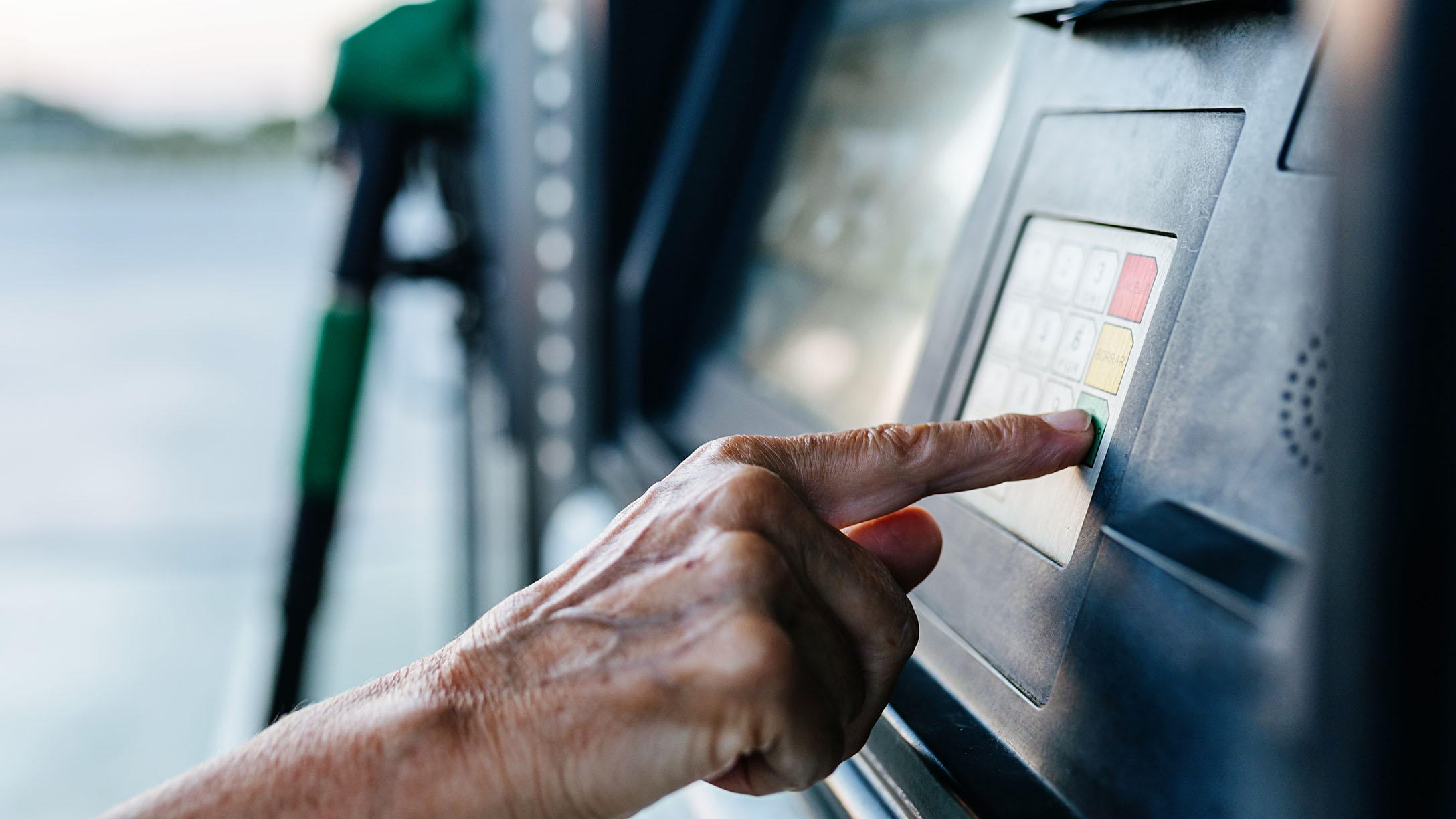 A hand punching in on the fuel kiosk