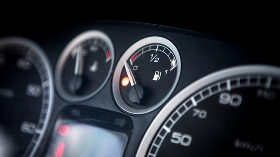 A closeup photo of the fuel gauge of a car