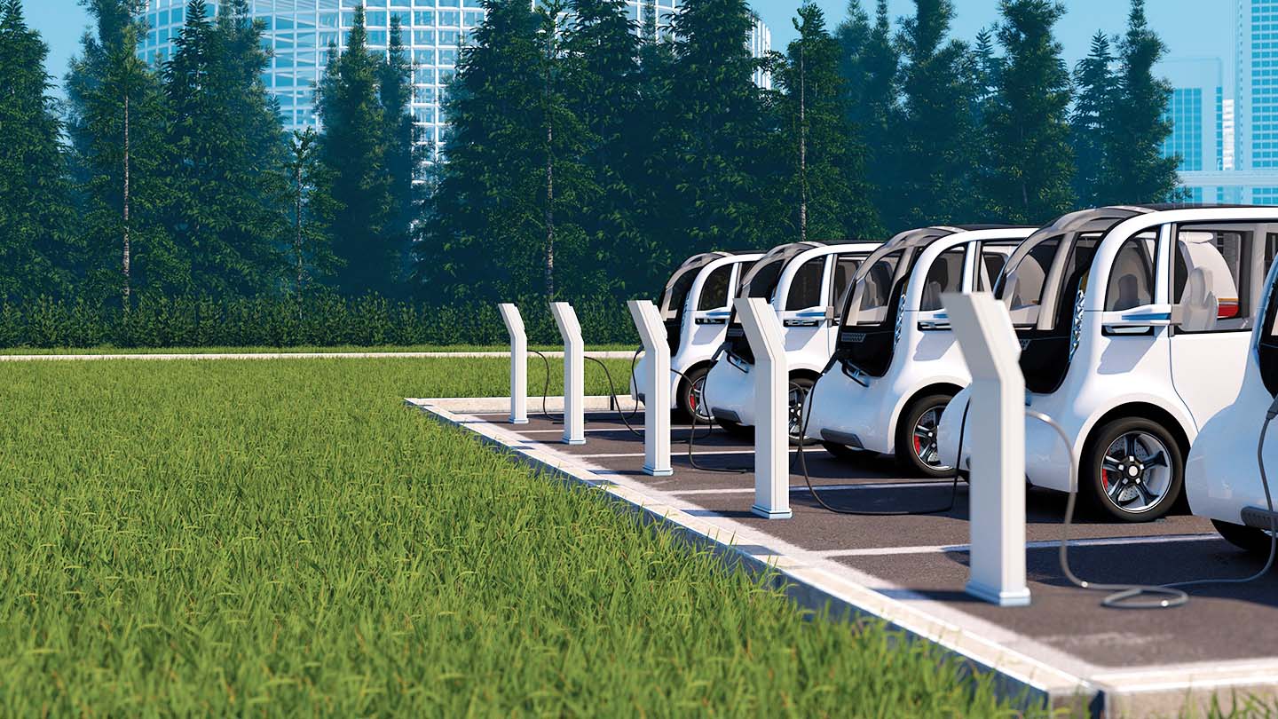 Multiple white electric vehicles plugged into charging stations