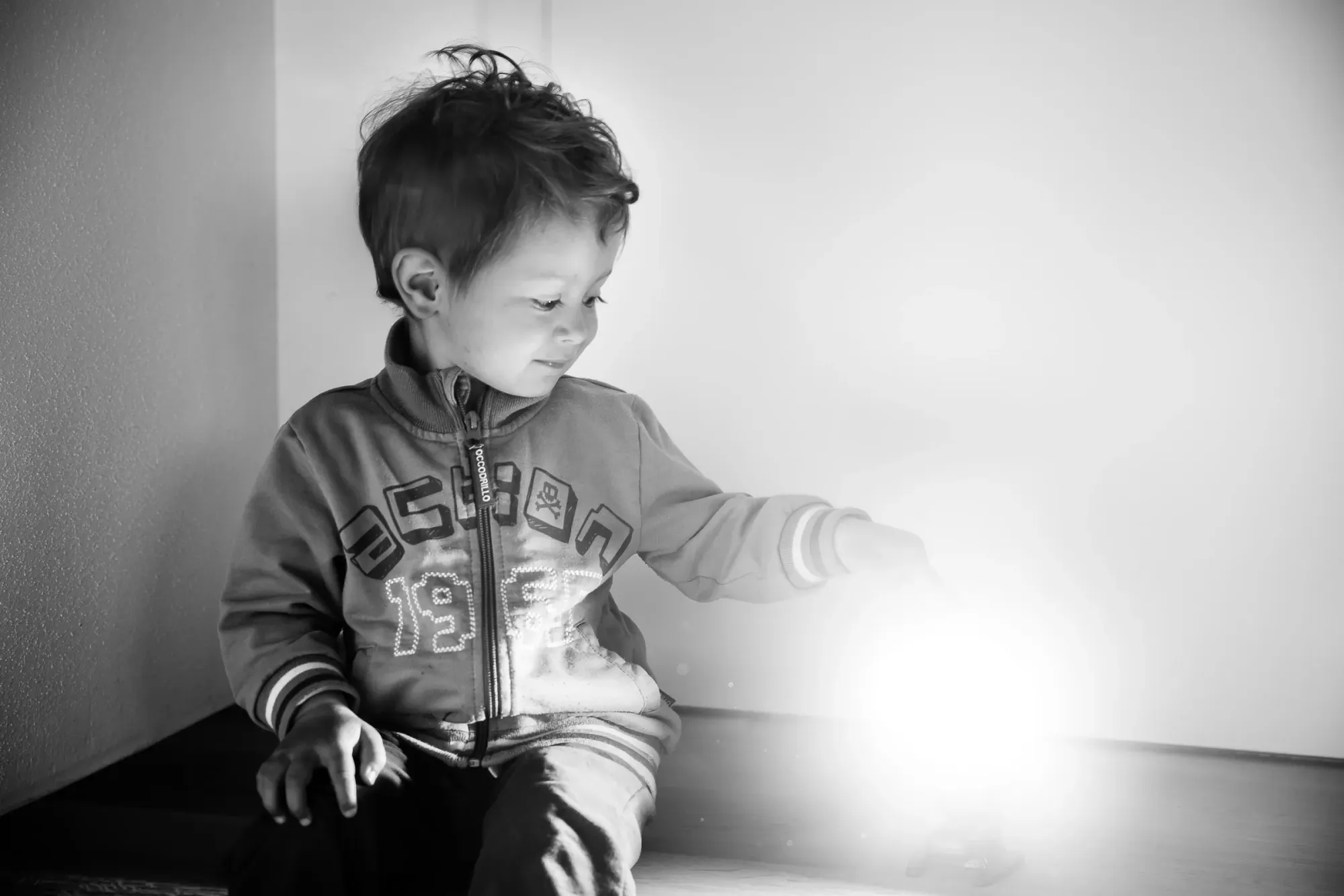 Ein Junge greift mit der Hand auf einen Lichtpunkt.