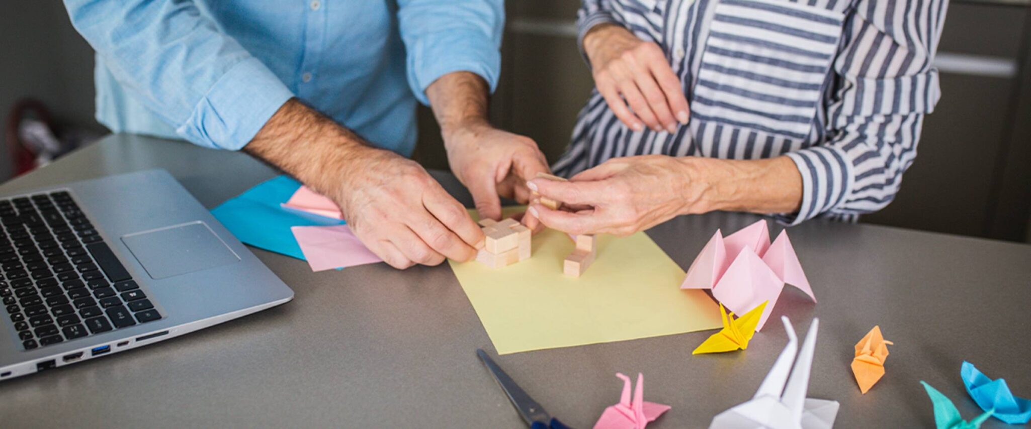 Two elderly people doing paper crafts at their retirement community