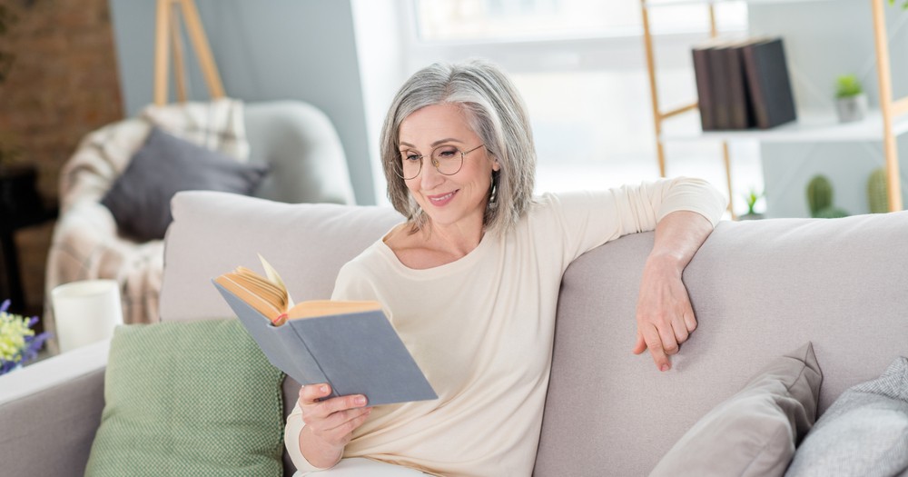 Happy senior woman reading a book