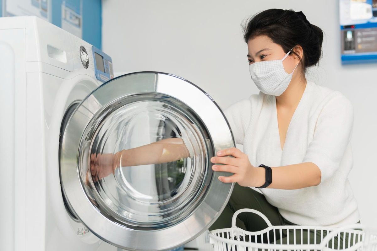 portrait-asian-female-wear-virus-protecting-mask-spread-covid19-washing-blue-color-interior-laundry-shop-condoiminuim-city-new-normal-lifestyle